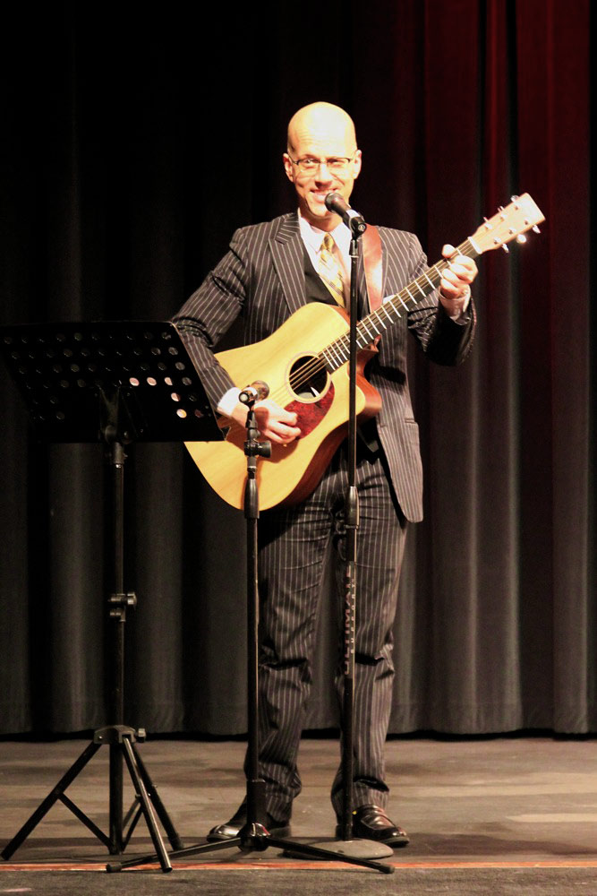 George Hrab on stage playing guitar